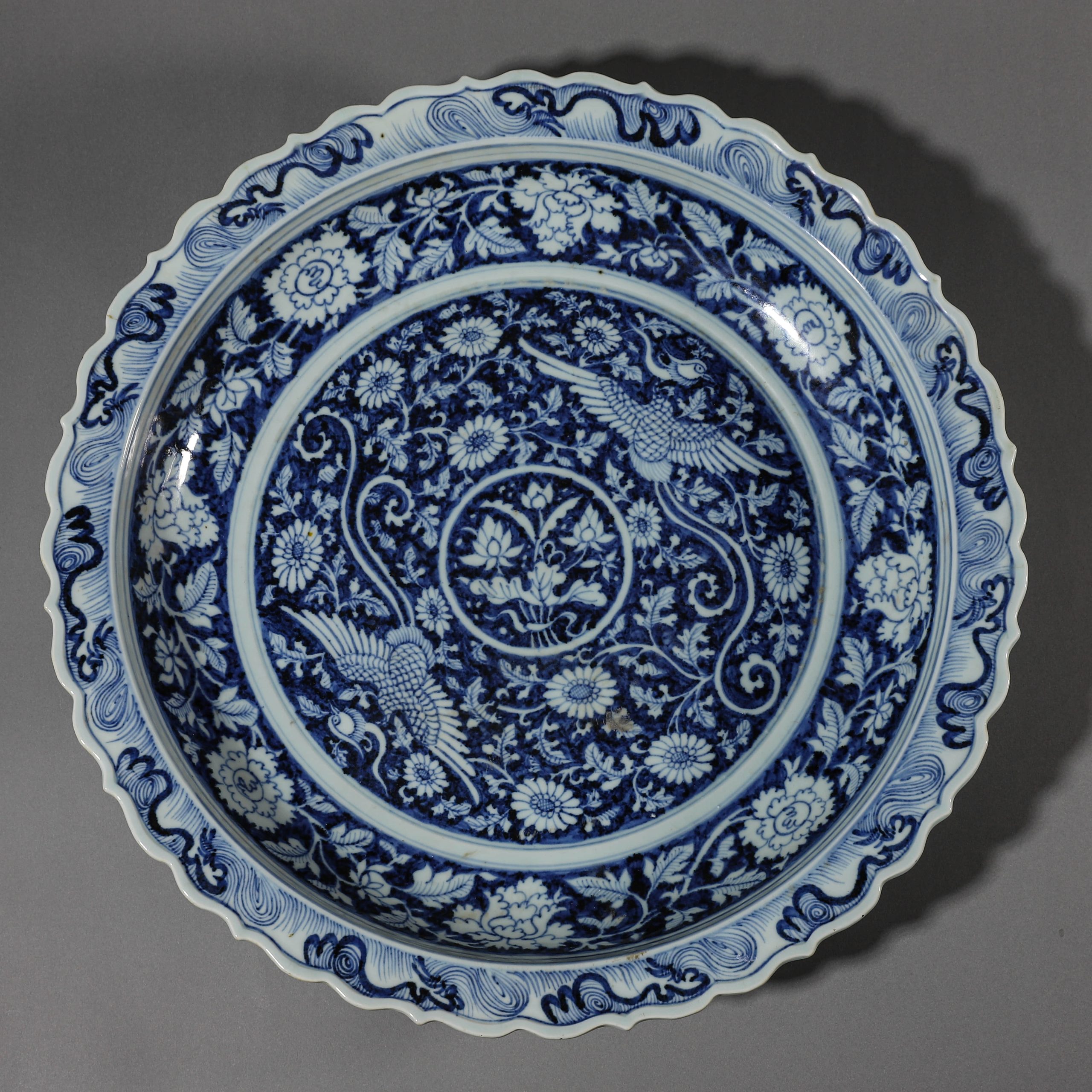 A CHINESE BLUE AND WHITE PLATE WITH PHOENIX AND FLORAL MOTIF, POSSIBLY QING DYNASTY.