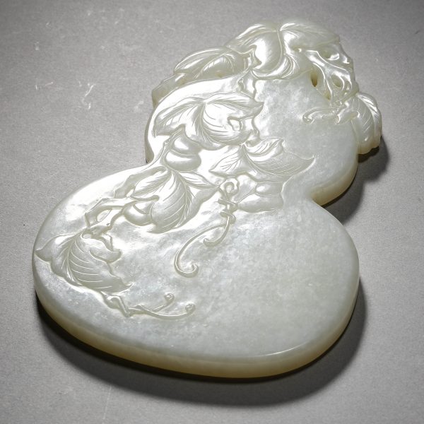 A CHINESE WHITE JADE GOURD CARVING SYMBOLIZING PROSPERITY AND ABUNDANCE